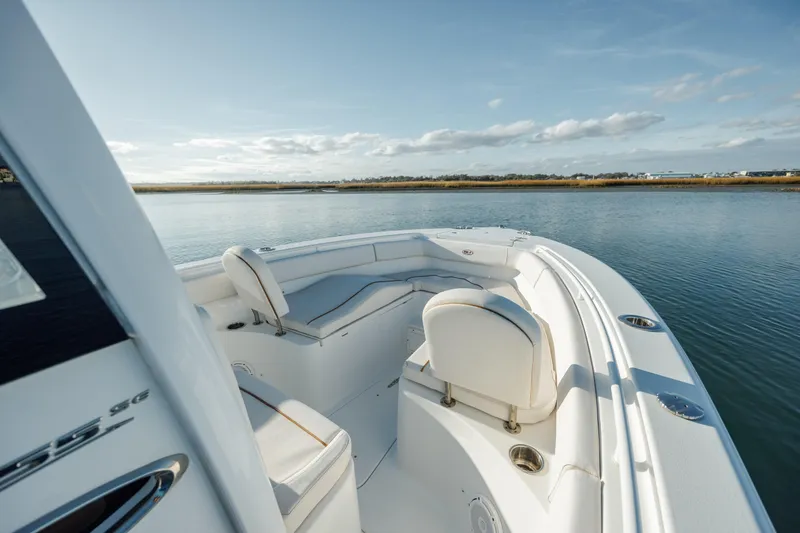 Slide: The Image of 2021 Sea Hunt Ultra 255 SE boat on calm water, featuring spacious seating. - 18