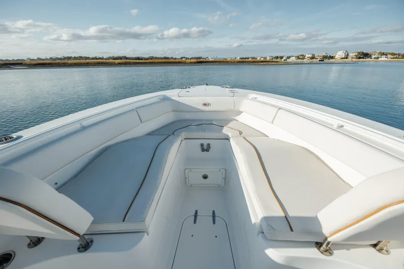 Slide: The Image of 2021 Sea Hunt Ultra 255 SE boat interior with spacious seating on calm water. - 19