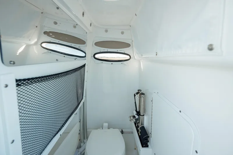 Slide: The Image of Interior of 2021 Sea Hunt Ultra 255 SE boat, featuring a compact marine toilet. - 22
