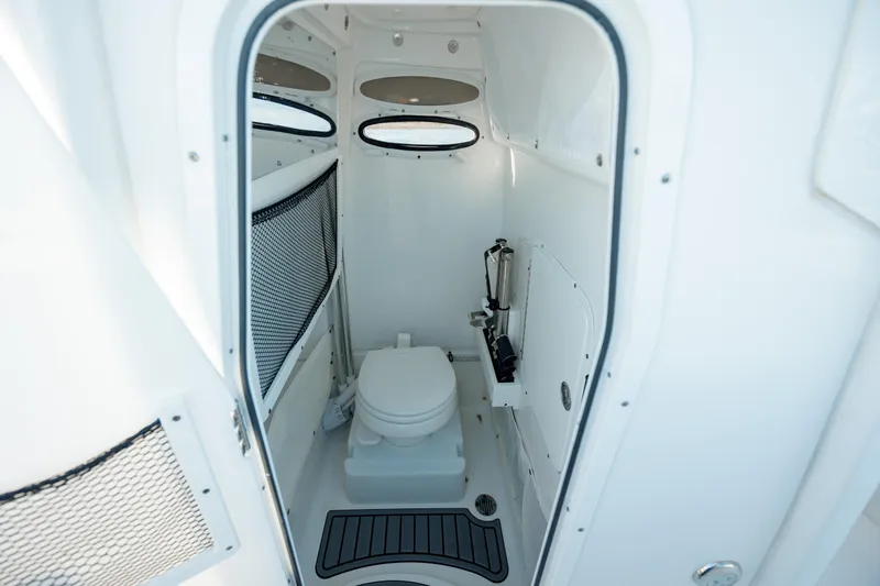 Slide: The Image of 2021 Sea Hunt Ultra 255 SE boat interior bathroom with toilet and storage. - 23