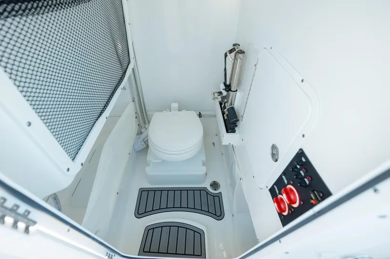 Slide: The Image of 2021 Sea Hunt Ultra 255 SE boat interior with toilet and control panel. - 26