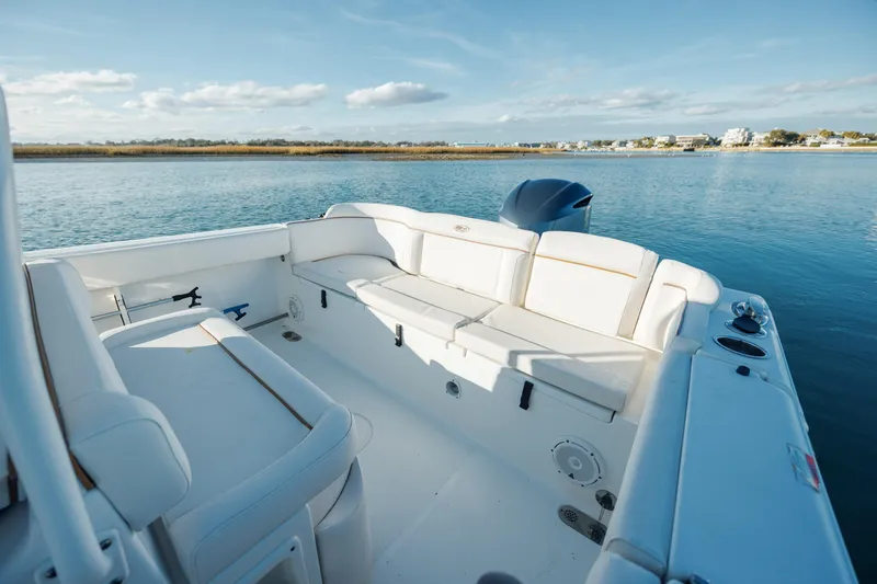 Slide: The Image of 2021 Sea Hunt Ultra 255 SE boat interior with spacious seating on calm water. - 9