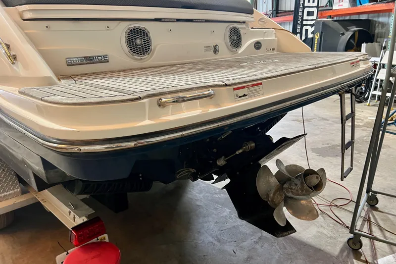 Slide: The Image of 2018 Sea Ray SLX 250 boat stern with propeller in a garage setting. - 14