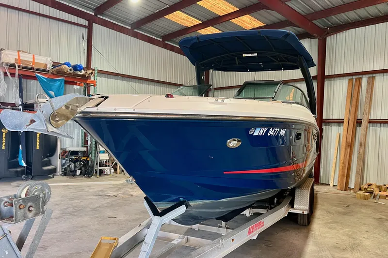 Slide: The Image of 2018 Sea Ray SLX 250 boat in a storage facility on a trailer. - 2