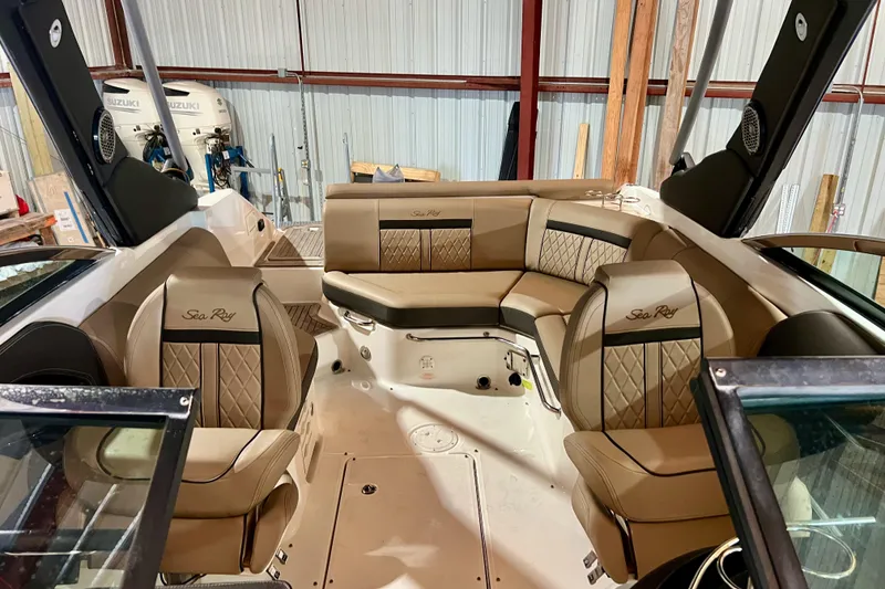 Slide: The Image of 2018 Sea Ray SLX 250 boat interior with tan leather seating in a storage facility. - 5