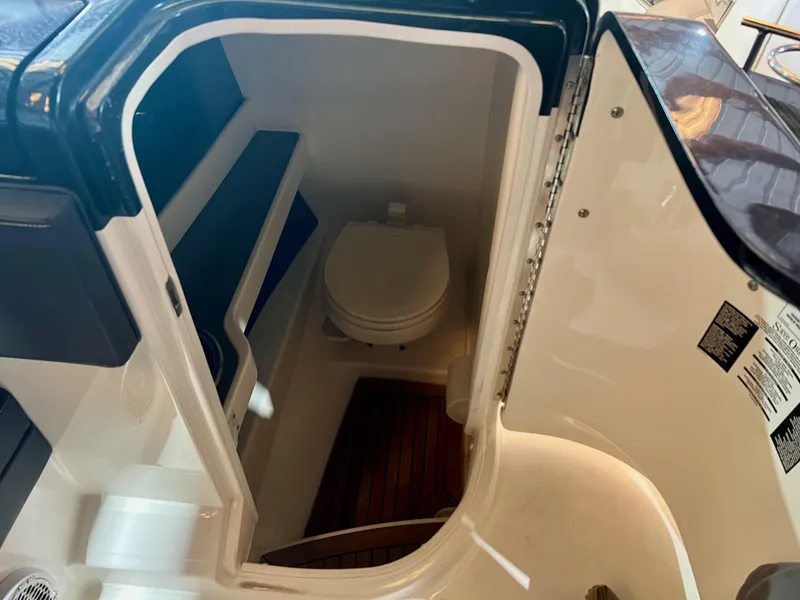 Slide: The Image of 2018 Sea Ray SLX 250 boat interior with compact marine toilet. - 9