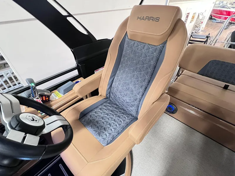 Slide: The Image of 2025 Harris Solstice 250 boat interior with luxury captain's chair and steering wheel. - 12