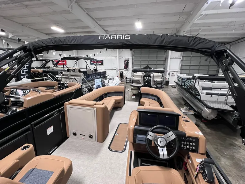 Slide: The Image of 2025 Harris Solstice 250 pontoon boat interior with tan seating and modern dashboard. - 2