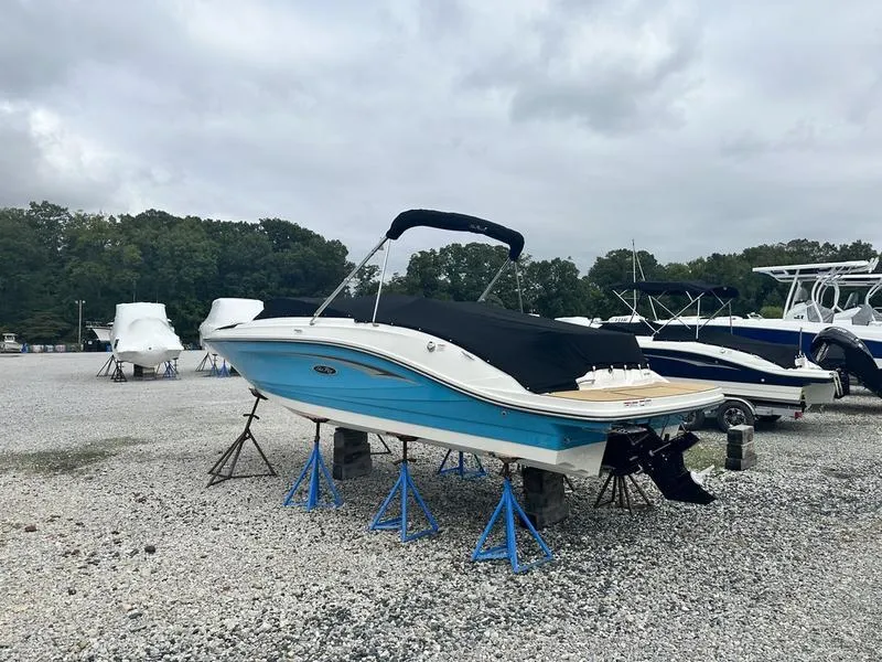 Slide: The Image of 2024 Sea Ray SPX 230 boat on stands in a gravel lot, covered and ready for storage. - 3