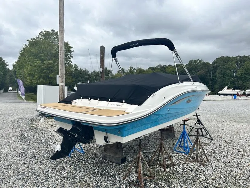 Slide: The Image of 2024 Sea Ray SPX 230 boat on stands, covered, in a gravel lot. - 4