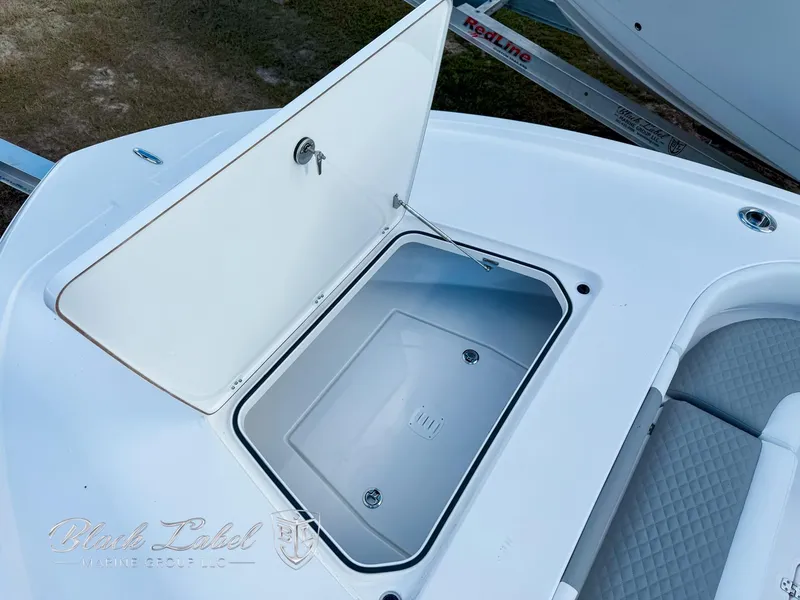 Slide: The Image of 2025 Caymas 281 HB boat storage compartment with open hatch, featuring sleek white design. - 10