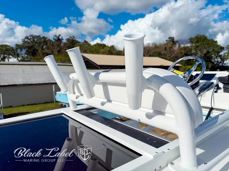 Slide: The Image of 2025 Caymas 281 HB boat with rod holders, steering wheel, and clear sky background. - 34