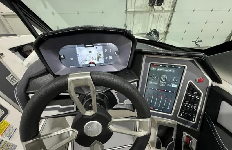 Slide: The Image of 2024 MasterCraft X24 boat in showroom, featuring sleek design and vibrant blue accents. - 14