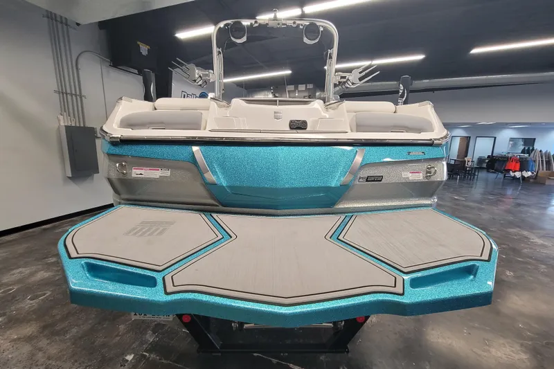 Slide: The Image of 2024 MasterCraft X24 boat with sleek design and vibrant blue finish in showroom. - 4