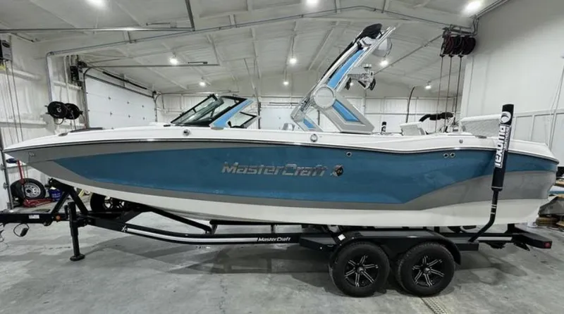 Slide: The Image of 2024 MasterCraft X24 boat interior with white and gray seating, cup holders, and speakers. - 5