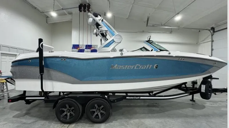 Slide: The Image of 2024 MasterCraft X24 boat interior with gray and white seating in showroom. - 8