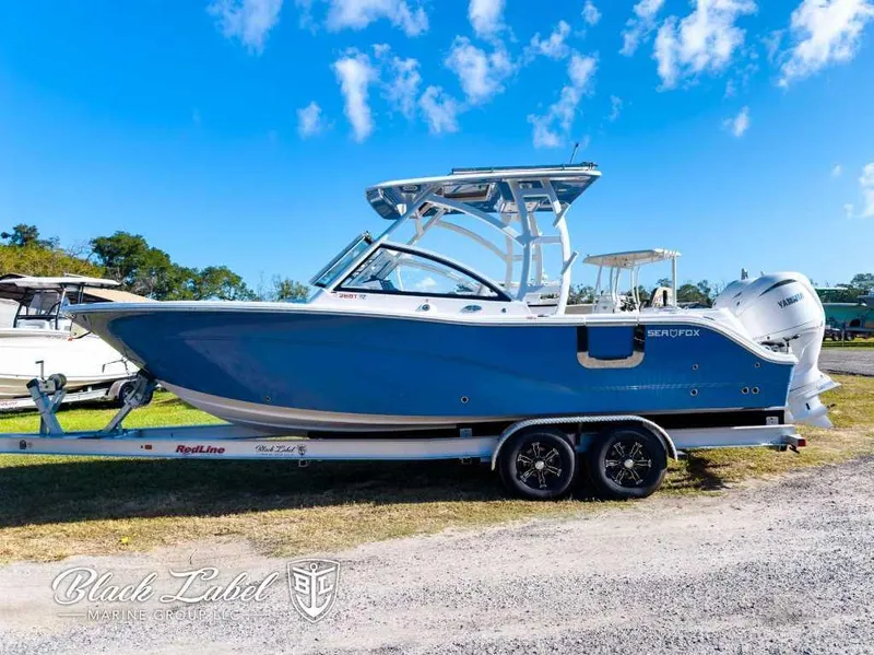 Slide: The Image of 2025 Sea Fox 268 Traveler Dual Console boat on trailer, blue sky background. - 0
