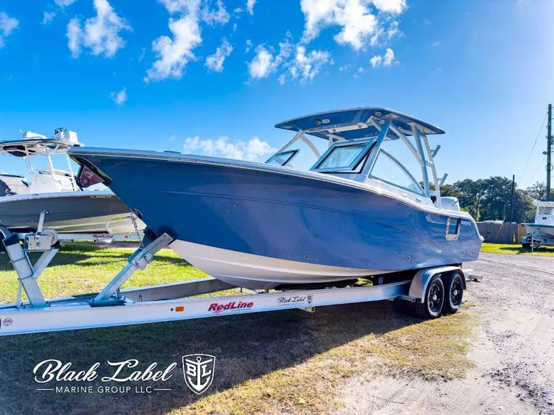 Slide: The Image of 2025 Sea Fox 268 Traveler Dual Console boat on trailer under clear blue sky. - 1