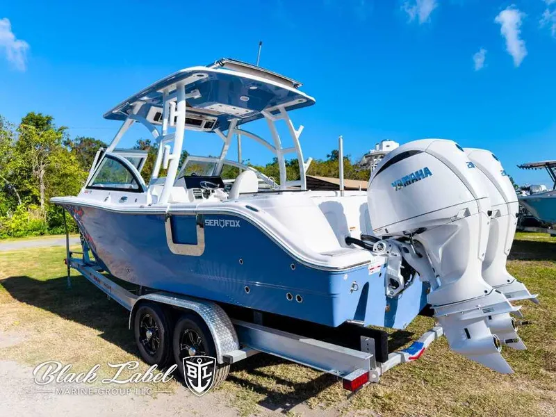 Slide: The Image of 2025 Sea Fox 268 Traveler Dual Console boat on trailer, featuring twin Yamaha engines. - 2
