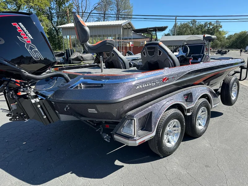 Slide: The Image of 2024 Ranger Z521R boat with dual axle trailer, parked outdoors. - 2