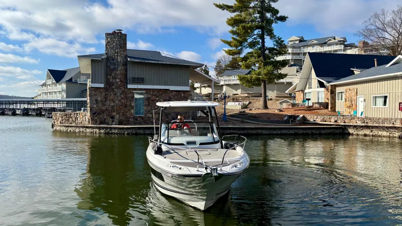 Slide: The Image of Jeanneau Leader 7.5 boat cruising near lakeside houses, 2022 model. - 2