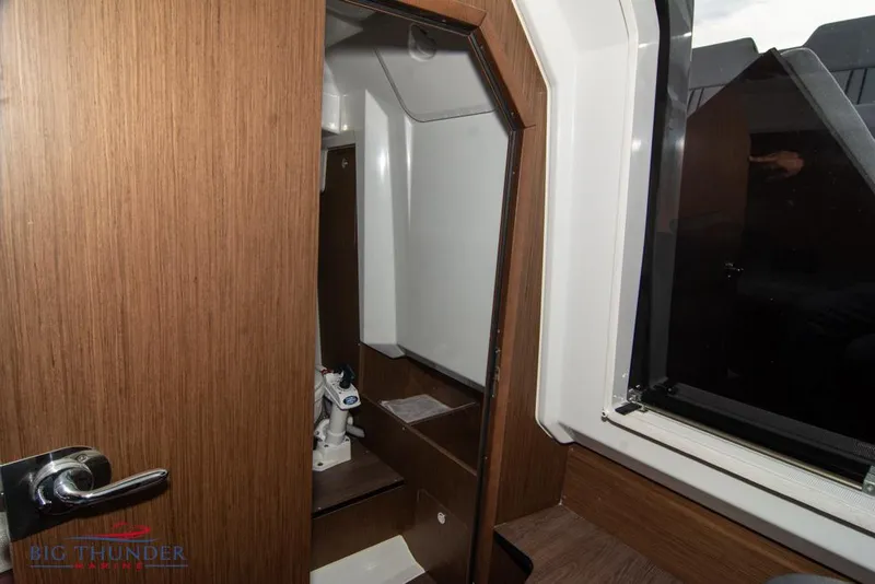 Slide: The Image of Interior cabin of 2022 Jeanneau Leader 7.5 boat, featuring wood paneling and a compact bathroom. - 26