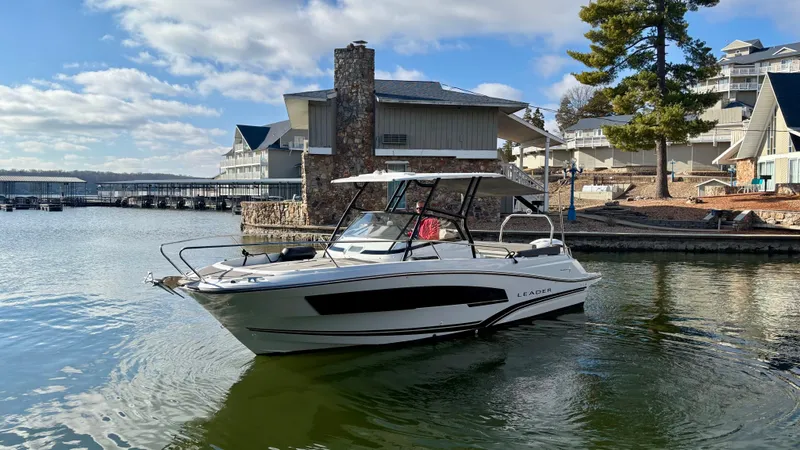 Slide: The Image of 2022 Jeanneau Leader 7.5 boat docked by lakeside buildings under a blue sky. - 3