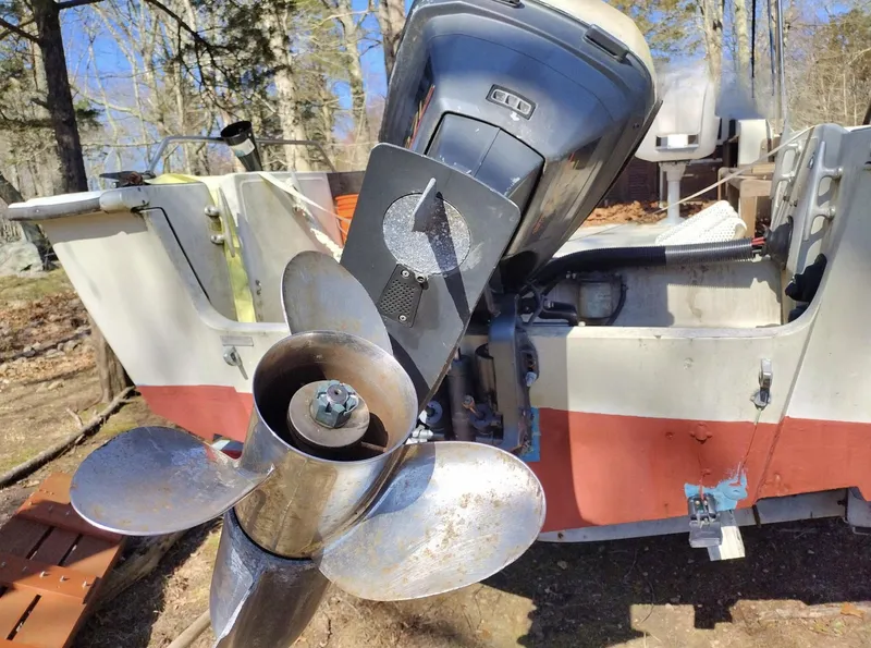 Slide: The Image of 1983 Boston Whaler 25 Revenge boat with outboard motor and propeller, parked outdoors. - 20