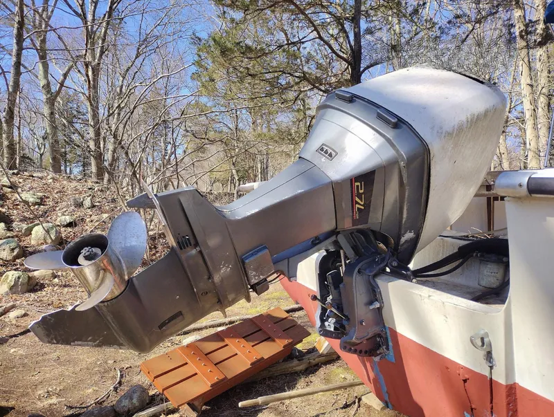 Slide: The Image of 1983 Boston Whaler 25 Revenge boat with outboard motor in wooded area. - 21