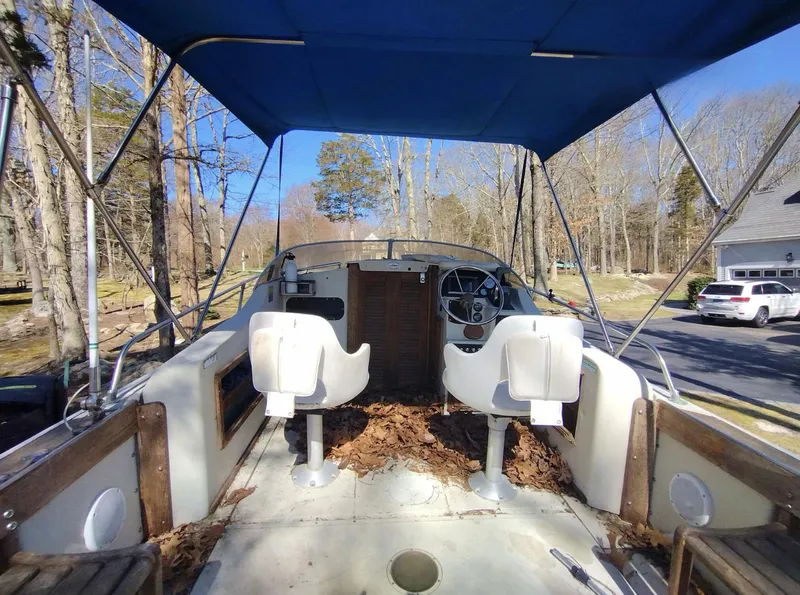 Slide: The Image of 1983 Boston Whaler 25 Revenge boat interior with blue canopy and two white seats. - 28