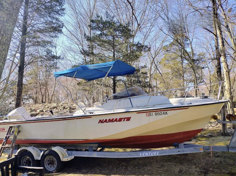 Slide: The Image of 1983 Boston Whaler 25 Revenge boat on trailer with blue canopy in wooded area. - 6