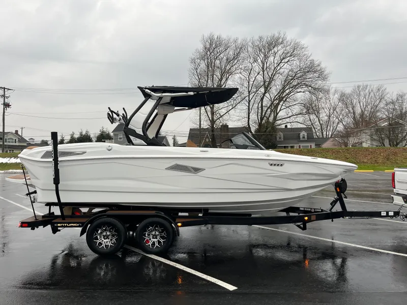 Slide: The Image of 2025 Centurion NV213 boat on trailer in parking lot, overcast day. - 10