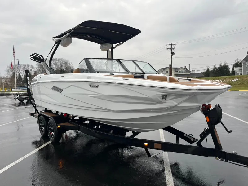 Slide: The Image of 2025 Centurion NV213 boat on trailer in parking lot, overcast sky. - 11