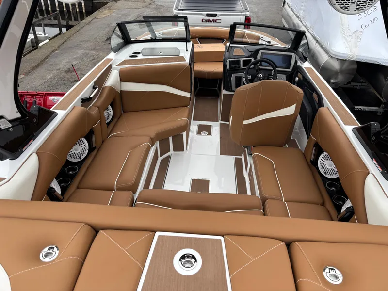Slide: The Image of 2025 Centurion NV213 boat interior with brown leather seating and modern dashboard. - 12