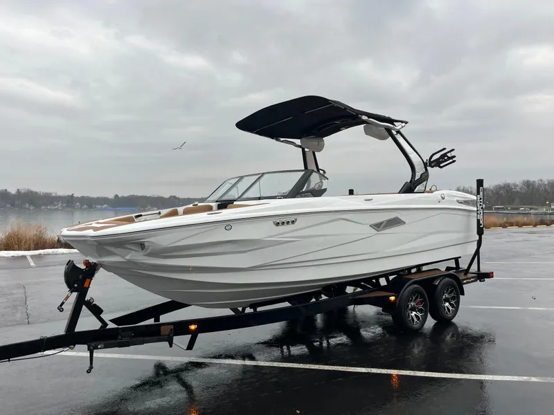 Slide: The Image of 2025 Centurion NV213 boat on trailer in parking lot, overcast sky. - 6