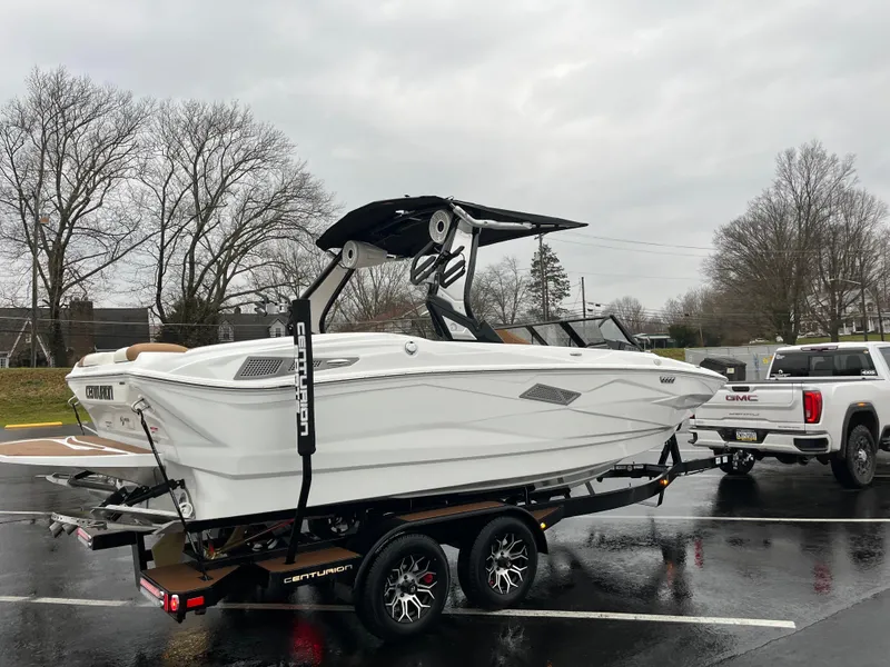 Slide: The Image of 2025 Centurion NV213 boat on trailer, parked in a lot on a cloudy day. - 9