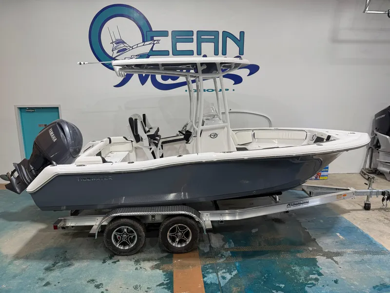 Slide: The Image of 2025 Tidewater 210LXF boat on trailer in showroom, featuring Yamaha outboard motor. - 1