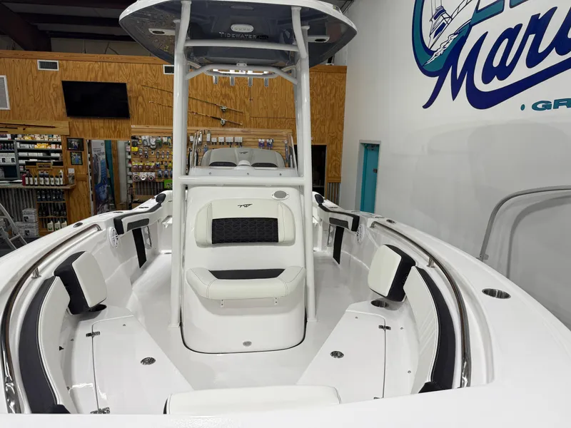 Slide: The Image of 2025 Tidewater 210LXF boat interior with seating and console in showroom. - 14