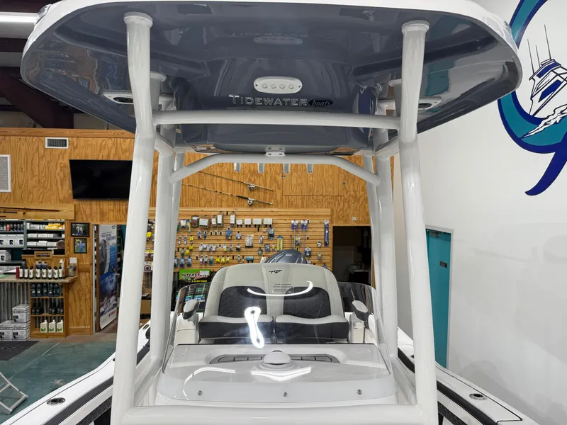 Slide: The Image of 2025 Tidewater 210LXF boat displayed in a showroom with fishing gear. - 36
