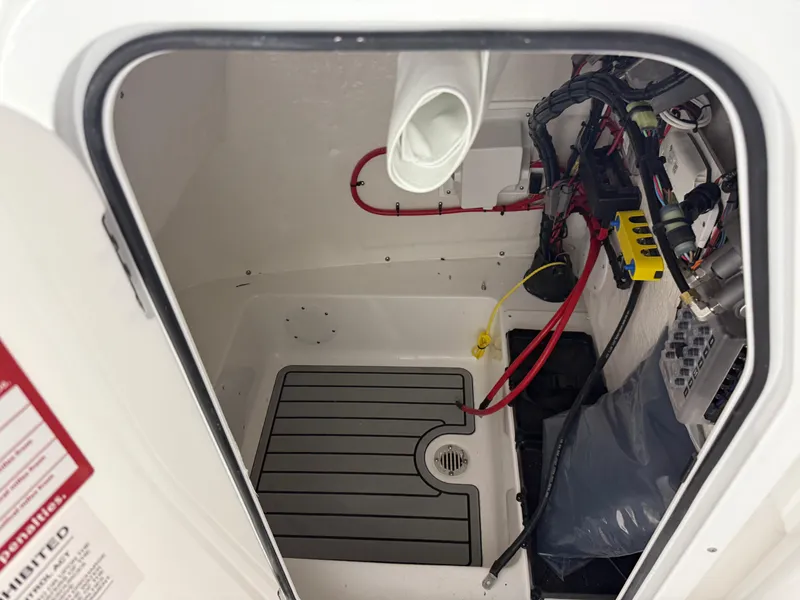 Slide: The Image of Interior view of 2025 Tidewater 210LXF boat compartment with wiring and storage space. - 42