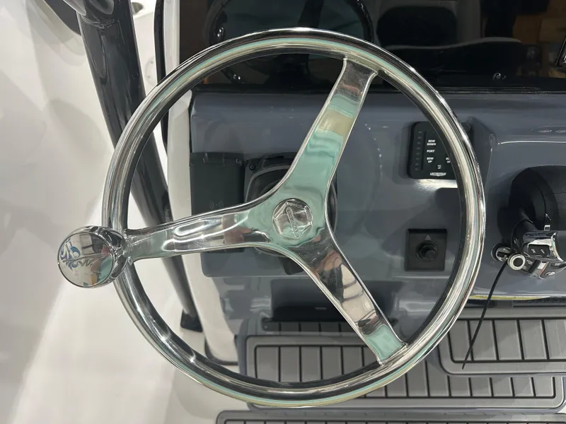 Slide: The Image of Steering wheel of 2025 Tidewater 220LXF boat, featuring sleek chrome design. - 21