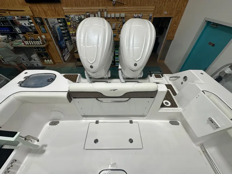 Slide: The Image of 2025 Tidewater 320cc boat interior with dual engines in a showroom setting. - 13