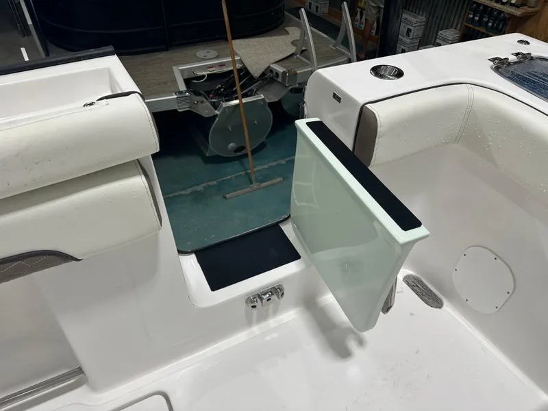 Slide: The Image of 2025 Tidewater 320cc boat interior with open transom door, white seating, and cup holder. - 16