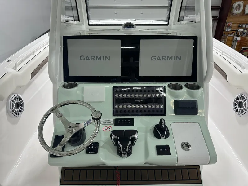 Slide: The Image of 2025 Tidewater 320cc boat dashboard with dual Garmin displays and steering wheel. - 21