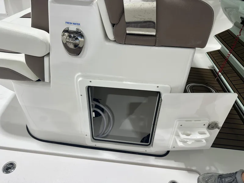 Slide: The Image of Tidewater 320cc 2025 boat interior with open storage compartment and fresh water access. - 24