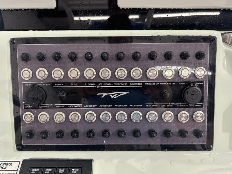Slide: The Image of Control panel of 2025 Tidewater 320cc boat with various switches and dials. - 27