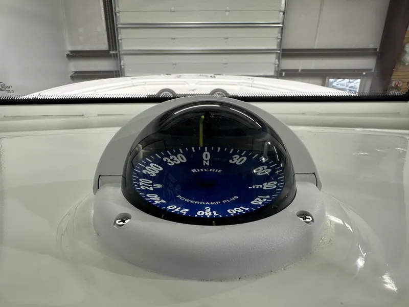 Slide: The Image of Compass on 2025 Tidewater 320cc boat dashboard in a garage setting. - 37