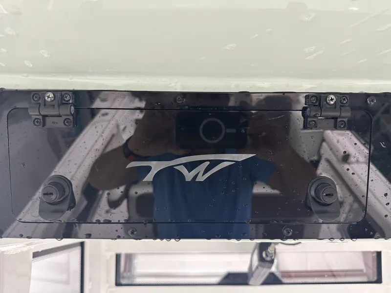 Slide: The Image of 2025 Tidewater 320cc boat dashboard with logo and reflective surface. - 39