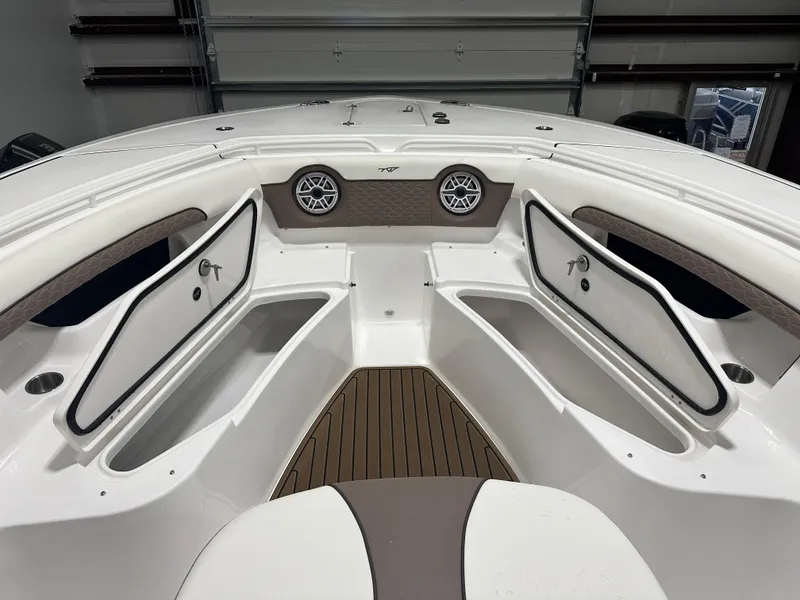 Slide: The Image of 2025 Tidewater 320cc boat interior with open storage compartments and speakers. - 42