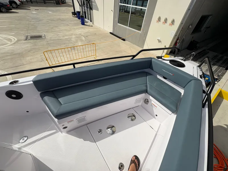 Slide: The Image of 2023 Axopar 28 AFT CABIN boat interior with gray seating and white deck. - 13